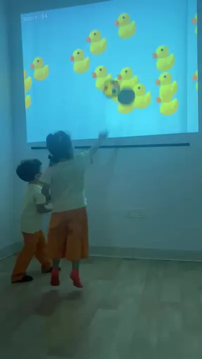 أطفال يلعبون أمام جدار تفاعلي